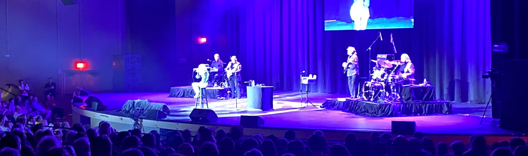 signer on stage in chair washed out by the lights Syracuse